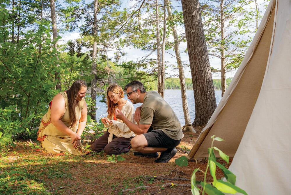 Couple with an interpretive guide on the Goat Island culture trail, Nova Scotia