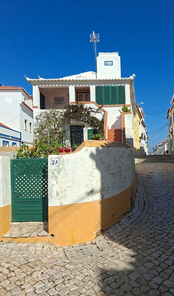 Cobbled streets and a colourful house in Ericeira's old town, Portugal