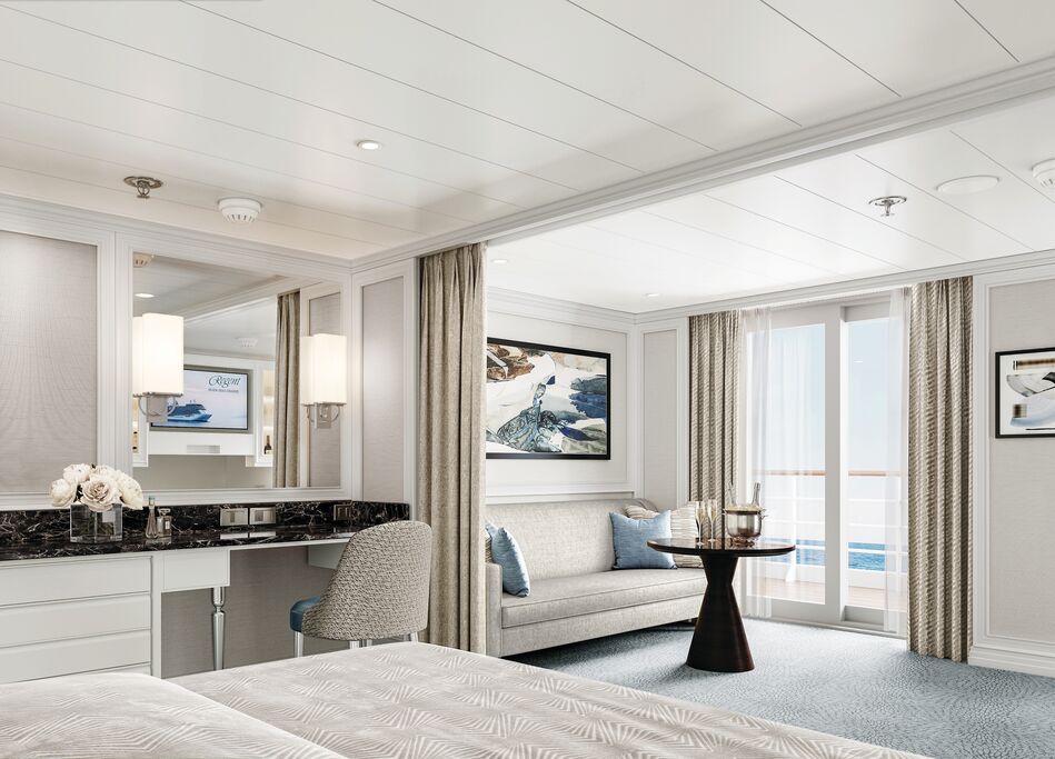 Inside a Deluxe Suite on a Regent Seven Seas Cruises ship showing bed and balcony.