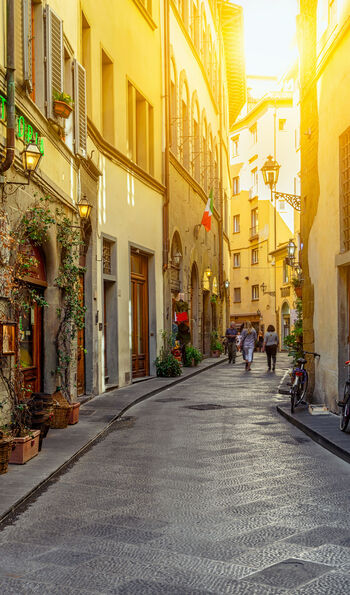 View of a narrow street at sunset in the heart of Florence, Tuscany.