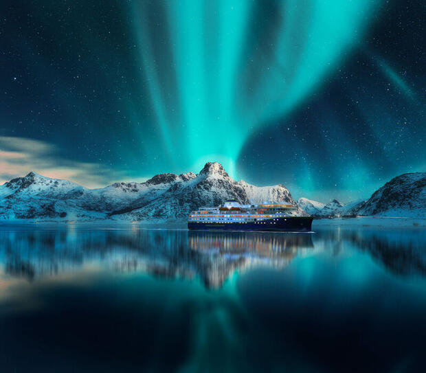 Northern Lights over a Havila Voyages cruise ship in Northern Norway