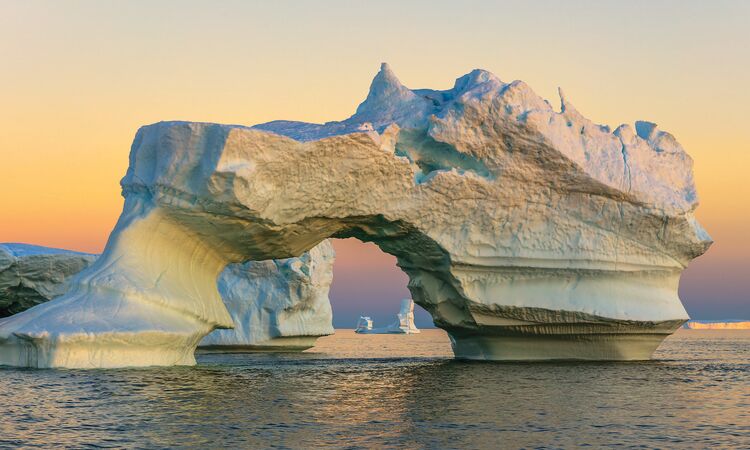 Spectacular Icebergs in Ilulissat, Greenland, bathed in warm evening light.