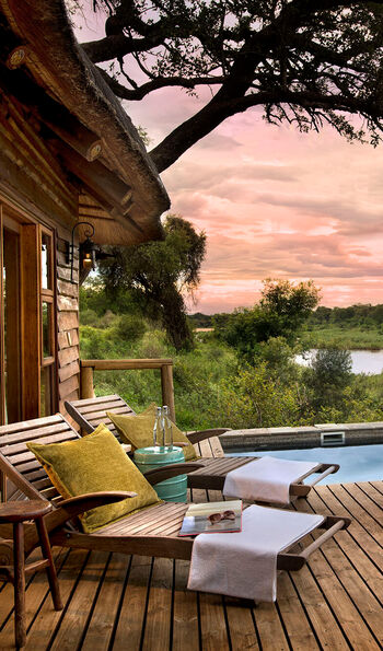 View out over decking with private pool to the bushveld beyond at Narina Lodge in Kruger National Park