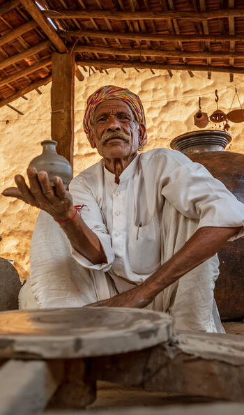 Potter at work makes ceramic dishes