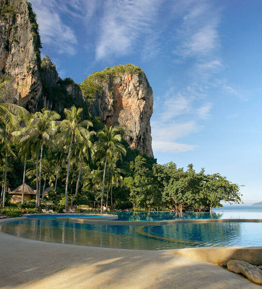 Image of Swimming Pool at Rayavadee with towering limestone cliffs and blue sky