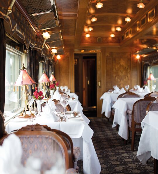 Image of Dining Car on the Eastern & Oriental Express, with crystal wine glasses and ornate lighting