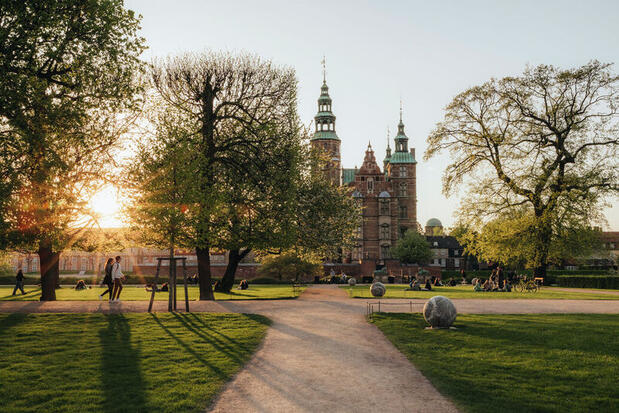 Rosenborg Castle and gardens with bright sun beaming through the clouds