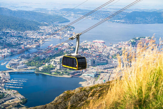 Image of a cable car ascending Mount Ulriken and view over the harbour behind