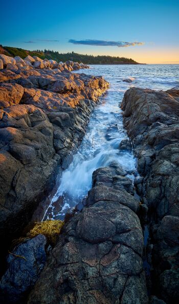 Waves flowing into rocky shore channel in Bay of Fundy, Nova Scotia